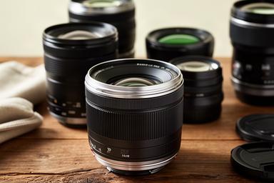 Lentes fotográficos de distintas focales colocados sobre una mesa de madera